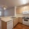 Spacious and well lit kitchen with wood flooring and stainless steel appliances