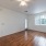 Spacious and well lit living room with wood flooring, large windows and open access to the kitchen